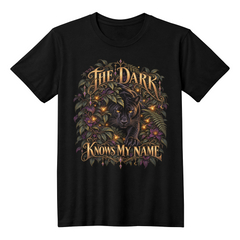 Black T-shirt featuring The Dark Knows My Name black panther design with golden lettering and dark foliage