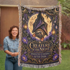 Woman holding Creature of the Night woven bat blanket outdoors